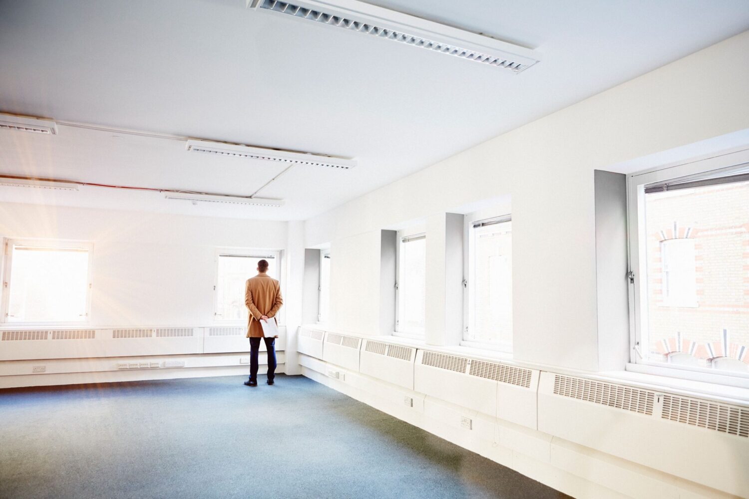 rear-view-of-man-in-empty-office-hands-behind-bac-2024-06-17-18-13-34-utc-1